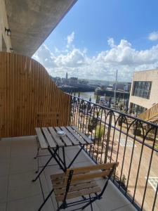 a table and chairs on a balcony with a view of the water at LA TOUR AUX CRABES près de la plage in Dieppe