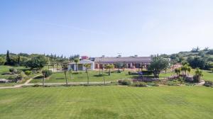 a large yard with a large house in the background at Quinta dos Poetas Nature Hotel & Apartments in Olhão
