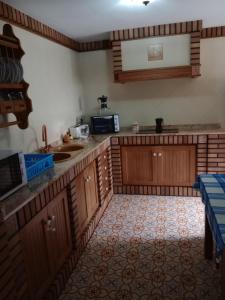 cocina con armarios de madera y encimera en Casa Paco en El Bosque