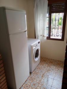 einen weißen Kühlschrank und eine Waschmaschine im Zimmer in der Unterkunft Casa Paco in El Bosque