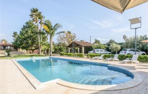 una piscina en un patio con sillas y árboles en Lovely Home In Comiso With House A Panoramic View en Comiso