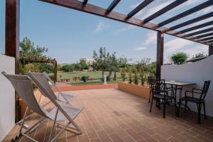 a patio with a table and chairs and a view at Quinta dos Poetas Nature Hotel & Apartments in Olhão