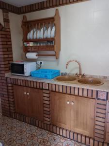 埃爾博斯克的住宿－Casa Paco，一间带两个水槽和微波炉的厨房
