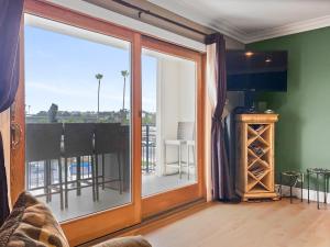 een woonkamer met een glazen schuifdeur en een balkon bij 311B Harbor Views and Steps to the Sand in Oceanside