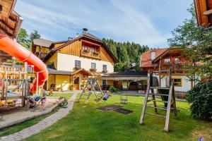 a playground in front of a house with a slide at Ferienwohnungen Simonbauer in Trebesing