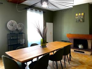 a dining room with a wooden table and chairs at Gîte du Grand Cellerier in Hautvillers