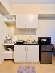 a kitchen with a sink and a microwave at I Best Value Studio in Iloilo City