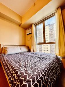 1 dormitorio con 1 cama grande y ventana en I Best Value Studio, en Iloilo City