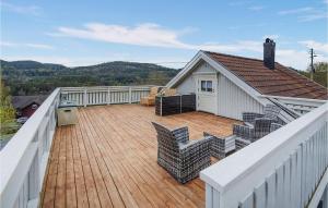 a large deck with chairs on top of a house at Amazing Home In Krager With Wifi And 3 Bedrooms in Kragerø