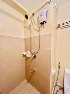 uma casa de banho com um chuveiro e um WC. em I Best Value Studio em Iloilo
