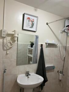 a bathroom with a sink and a mirror at Davao Vacation Hub near Sasa ferry terminal with netflix,Wifi, pool access in Davao City
