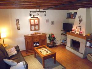 sala de estar con sofá y chimenea en El Roble. Azagalla Rural, en Casas del Abad
