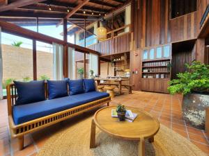 a living room with a blue couch and a table at Athita The Hidden Court Chiang Saen Boutique Hotel in Chiang Saen