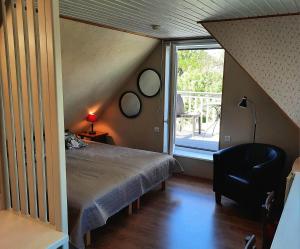 1 dormitorio con cama, ventana y silla en Apartment Pärna, en Kuressaare