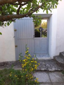 a door to a house with yellow flowers in front at Chambre d'hôtes ici in Bédoin