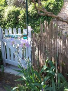 a white bench sitting next to a wooden fence at Chambre d'hôtes ici in Bédoin