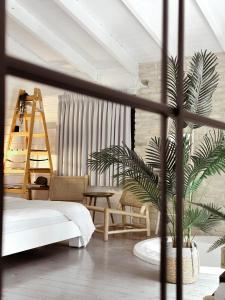 een woonkamer met een bed en een plant bij Eili Suites in Moshav Ramot
