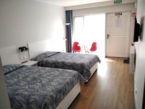 Pokój hotelowy z 2 łóżkami i czerwonym krzesłem w obiekcie Motel Express w mieście Bogucin