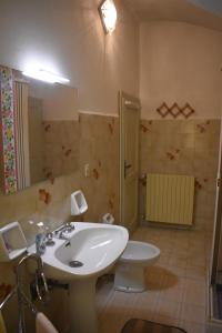 ein Badezimmer mit einem weißen Waschbecken und einem WC in der Unterkunft La casa dei libri in Pontremoli