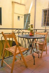 einen Tisch und zwei Stühle auf einem Balkon mit einem Tisch und einem Tisch in der Unterkunft La casa dei libri in Pontremoli