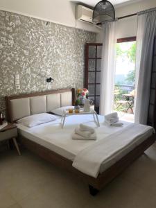 1 dormitorio con 1 cama grande y toallas. en Armonia Guest House Skiathos, en Skiathos