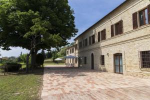 a large brick building with a tree next to it at Locanda di Montegiove in Fano