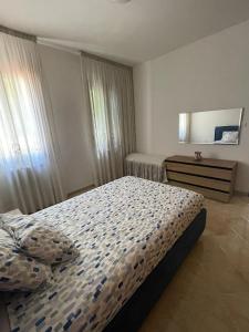 1 dormitorio con cama, tocador y espejo en A Casa dei Nonni, en Cavallino-Treporti