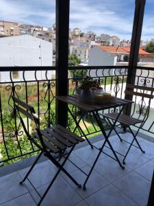 una mesa y sillas en un balcón con vistas en Armonia Guest House Skiathos, en Skiathos