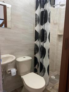 łazienka z toaletą i zasłoną prysznicową w obiekcie Hospedaje Campestre Villa Niny w mieście San Gil