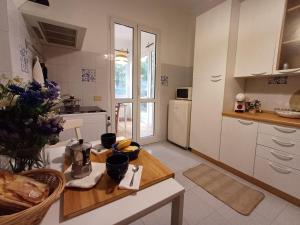 uma cozinha com armários brancos e uma mesa de madeira com uma mesa de sidx em The sea road house em Génova
