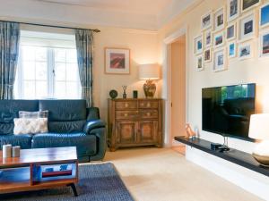 a living room with a couch and a tv at Granton Lodge in Far Sawrey