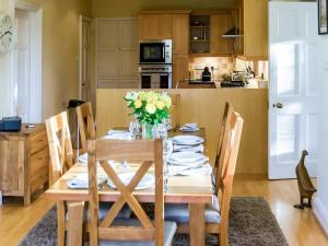 a dining room with a table with flowers on it at Granton Lodge in Far Sawrey