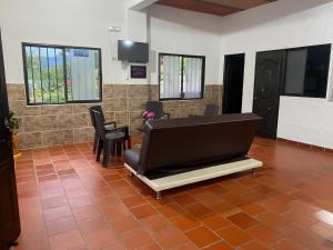 salon z dużą kanapą na podłodze wyłożonej kafelkami w obiekcie Hospedaje Campestre Villa Niny w mieście San Gil