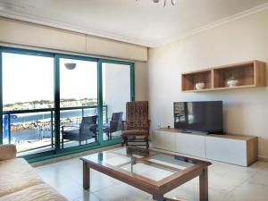 a living room with a tv and a glass coffee table at Desconectaengalicia Puerto de Portonovo in Portonovo