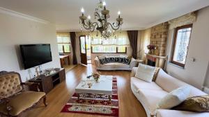 a living room with a couch and a tv at Heaven Garden Villa in Trabzon