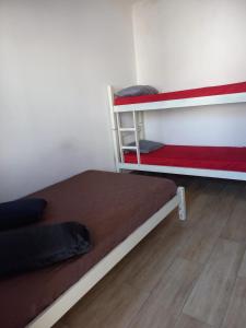 sypialnia z 2 łóżkami piętrowymi i drewnianą podłogą w obiekcie Hostel Mar da Vila w mieście Praia Grande