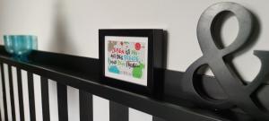 a framed picture sitting on a rail next to a glass at Villa Kunterbunt, Gemütlichkeit am Waldesrand in Drangstedt