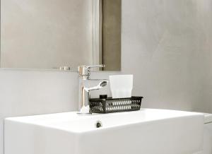 a bathroom sink with a faucet and a mirror at Plaza Hotel in Loutraki