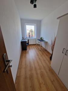 une pièce vide avec une table et une fenêtre dans l'établissement Przytulny apartament + siłownia, à Bytom