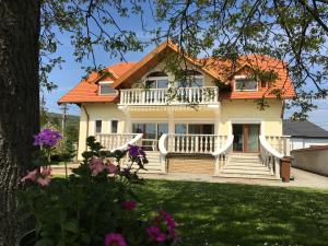 una gran casa blanca con techo naranja en Csók Apartmanház, en Balatonfüred