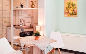 Cozy Apartment In Bad Schandau- Kleing, With Wifi في Kleingießhübel: مطبخ صغير مع طاولة وكراسي بيضاء