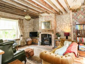 sala de estar con sofá y chimenea en Rose Cottage en Dorchester