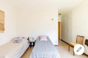 Villa Adelina的住宿－Habitación con baño privado Regis Haus，一间卧室配有两张床、一张桌子和一把椅子