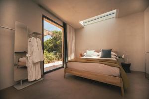 a bedroom with a bed and a large window at Rakalia Pure Living Sicilian Retreat in Marsala