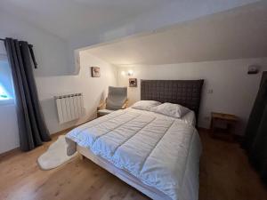 - une chambre avec un grand lit et une chaise dans l'établissement Appartement étoilé duplex tout confort, à Gérardmer