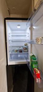 um frigorífico com a sua porta aberta com comida no interior em Cozy room Central London - zone 2 - Stockwell em Londres