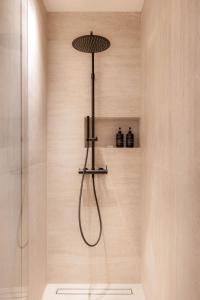 a shower with a shower head in a bathroom at Doryssa Theorem Hotel in Pythagoreio