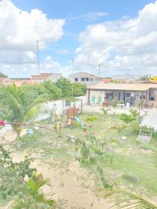 um pátio com parque infantil e um edifício em Pousada Monte Carlos em Galinhos