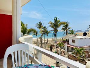 einen Balkon mit Blick auf den Strand und die Palmen in der Unterkunft Los Angeles en el Paraiso in San Patricio - Melaque