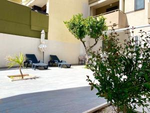 un patio con sedie e ombrellone in un edificio di Casa al mare - Puglia Mia Apartments a Monopoli